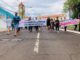 A passeata seguiu por ruas do centro de Foz para sensibilizar comunidade sobre condicoes de trabalho dos educadores. Assessoria