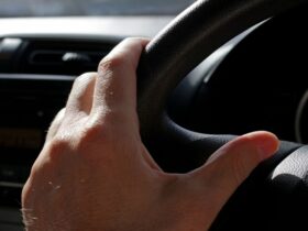 hand on car steering wheel