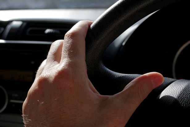 hand on car steering wheel